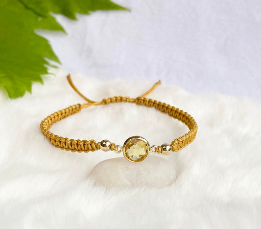 A gold-colored bracelet with a golden pendant