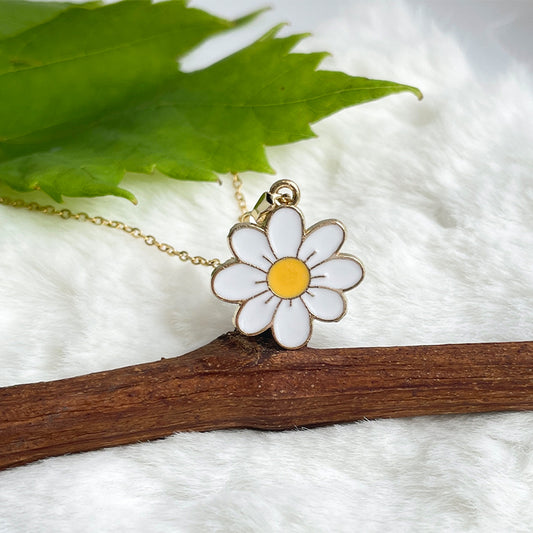 A gold necklace with daisy pendant